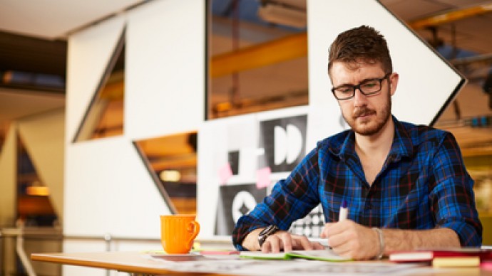 A postgraduate student working on creative designs in a campus studio